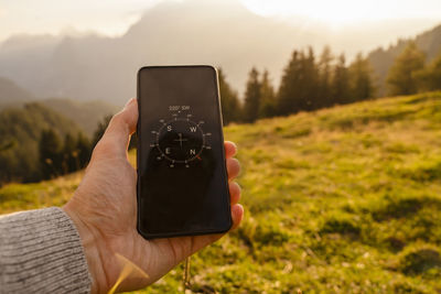 Hand of man showing compass on smart phone