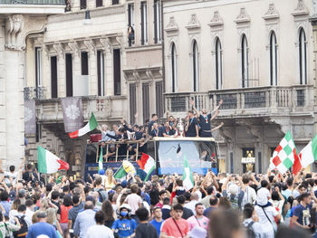 People on street against buildings in city