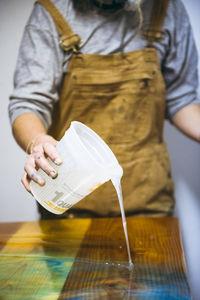 Closeup of female resin artist hands pouring new artwork