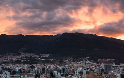 Townscape by mountains against sky during sunset