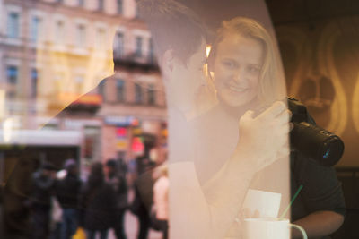 Man and woman using camera while sitting at restaurant