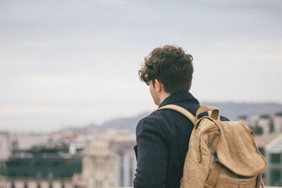 Rear view of man standing against cityscape