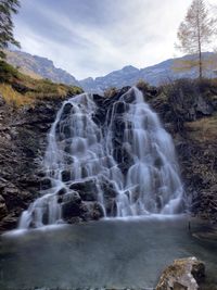 Scenic view of waterfall against sky