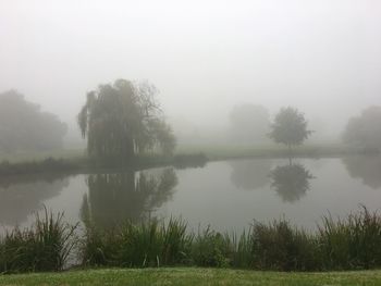 Scenic view of lake against sky during foggy weather