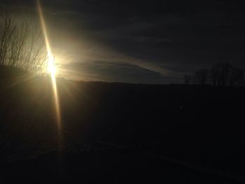 Scenic view of silhouette field against sky at sunset