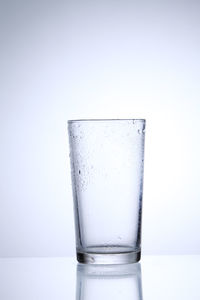 Close-up of empty drinking glass against white background