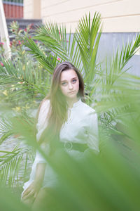 Portrait of young woman with palm tree