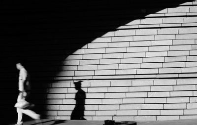 Shadow of man walking on tiled floor