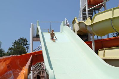 Low angle view of man swimming in pool against clear sky