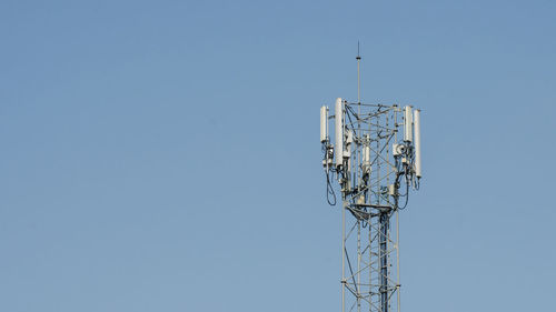 Low angle view of communications tower against clear blue sky