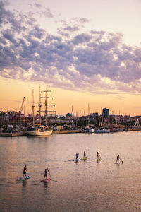 Sailboats in sea against sky during sunset