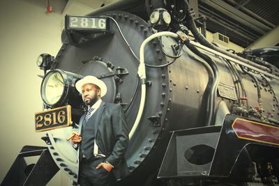 Low angle view of man standing against old train