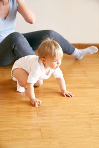Cute girl crawling on floor at home