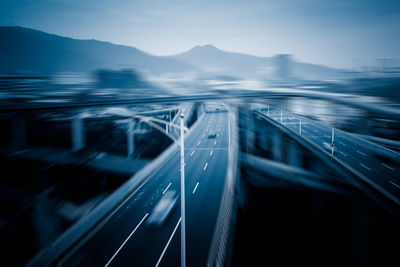 Blurred motion of train in city against blue sky