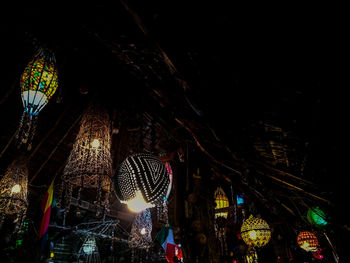 Low angle view of illuminated lanterns hanging in building at night