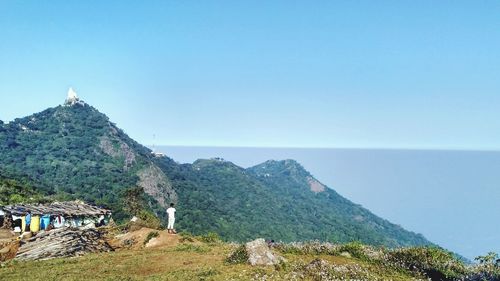 Scenic view of sea and mountains against clear sky