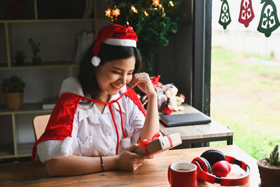 Woman looking away while sitting on table