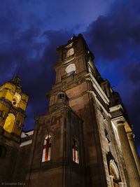 Low angle view of clock tower against sky at night