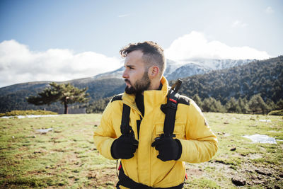 Young man with yellow jacket and backpack in the mountains.