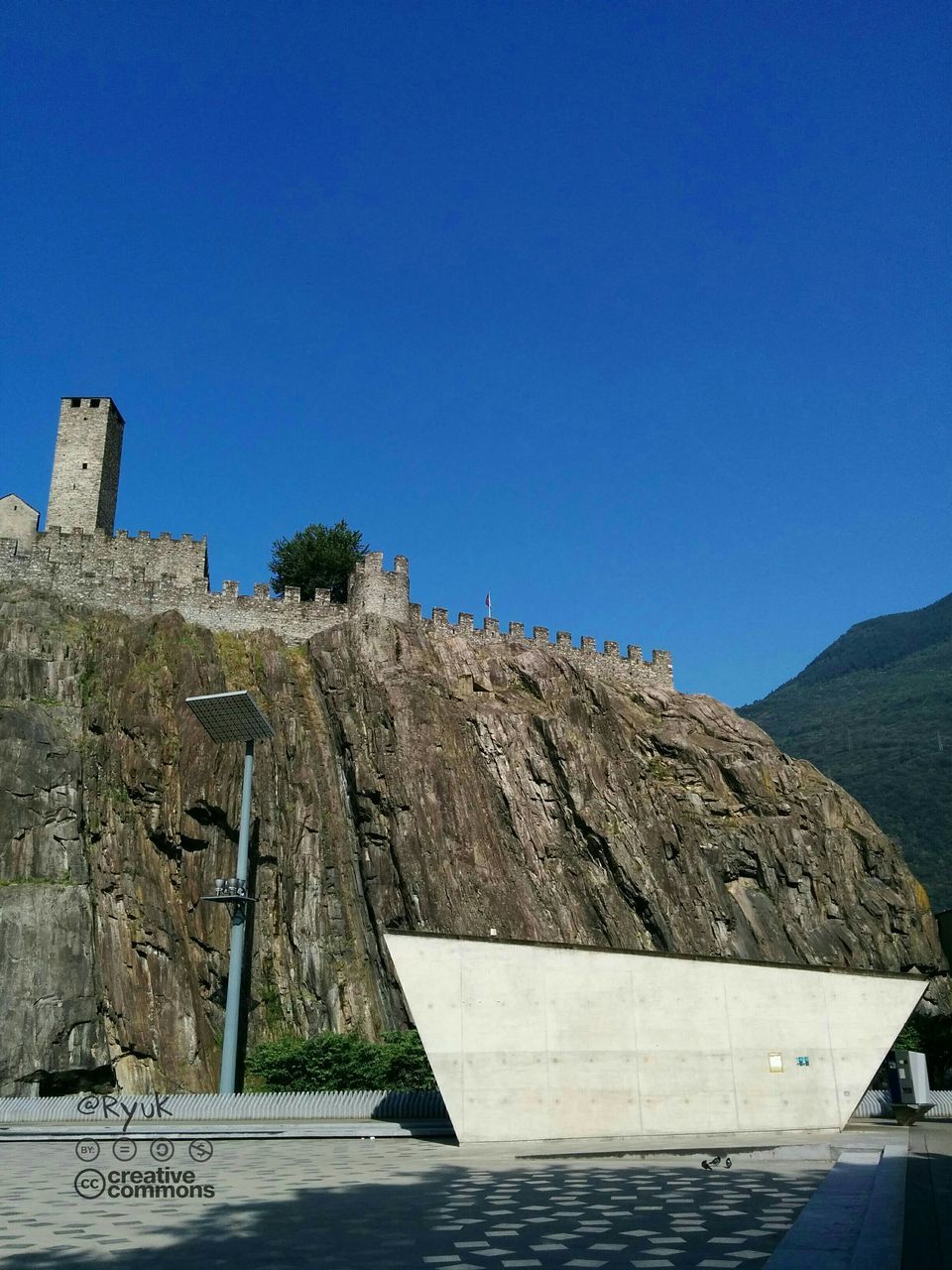 clear sky, copy space, blue, built structure, tranquility, sunlight, tranquil scene, nature, architecture, water, steps, day, rock - object, scenics, sea, beauty in nature, outdoors, mountain, building exterior, wood - material