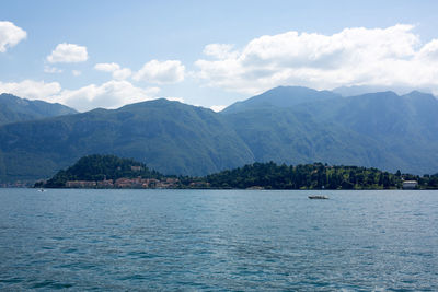 Scenic view of lake by mountains against sky