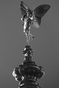 Low angle view of angel statue against sky