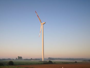 Windmill on field against clear sky