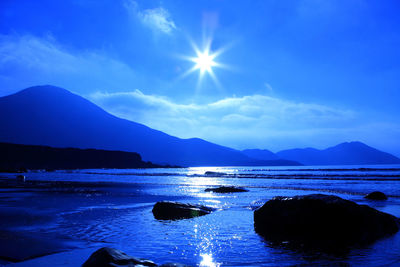 Scenic view of sea and mountains against sky