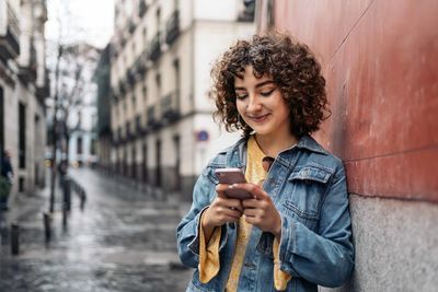 Young woman using mobile phone in city