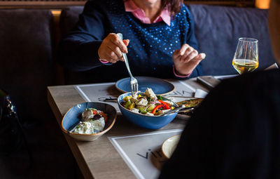 High angle view of woman eating food in restaurant