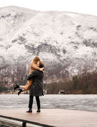 Full length of woman standing on lake against mountain