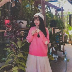 Portrait of woman standing against pink plants