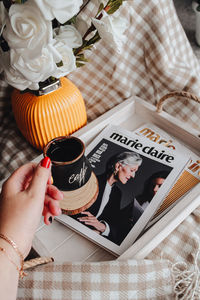High angle view of woman hand holding book on table