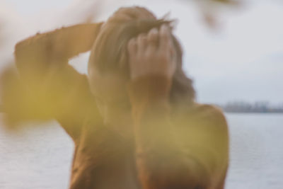 Rear view of shirtless woman in water