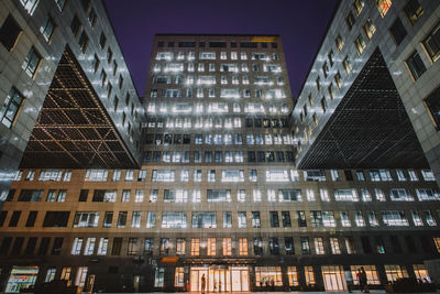 Low angle view of illuminated modern building at night