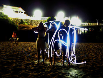 Man holding illuminated lighting equipment at night