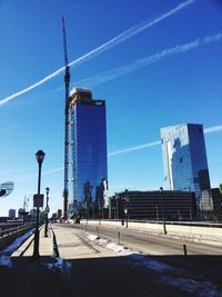 Low angle view of incomplete skyscraper against blue sky