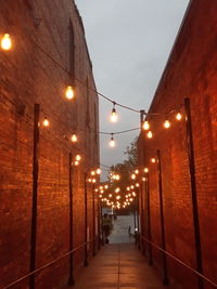 Illuminated street amidst buildings at night