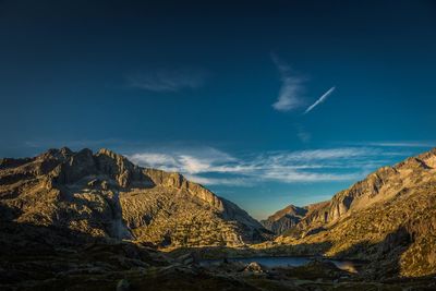 Scenic view of mountains against blue sky