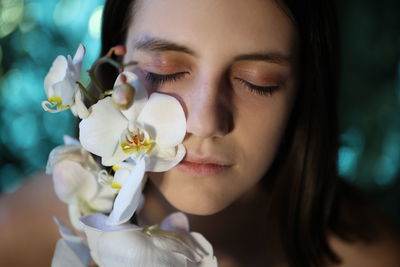 Close-up of young woman holding flower