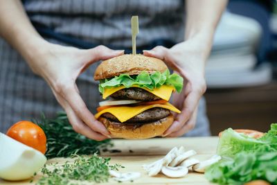 Midsection of woman holding burger