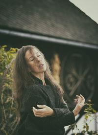 Woman in romantic pose between rustic houses, slovenia