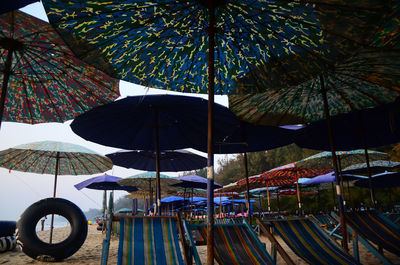 Low angle view of umbrellas hanging at beach