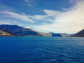 View of calm blue sea against mountain range