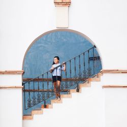 Full length of young woman standing on staircase