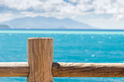 Wooden post in sea against sky