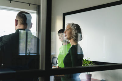 Business colleagues in green clothing standing in office