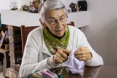 Senior woman sewing mask at home