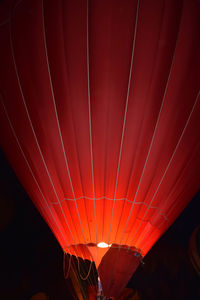 Illuminated orange hot air balloon at dusk