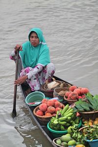 Woman selling food on boat in lake